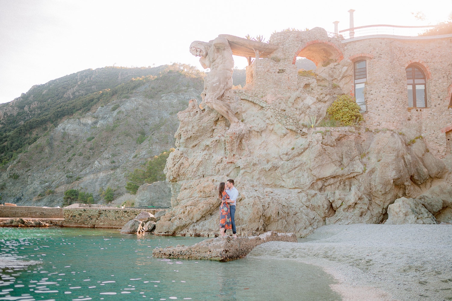 a kiss during an engagement portrait session at la Fegina beach in Monterosso under the giant statue