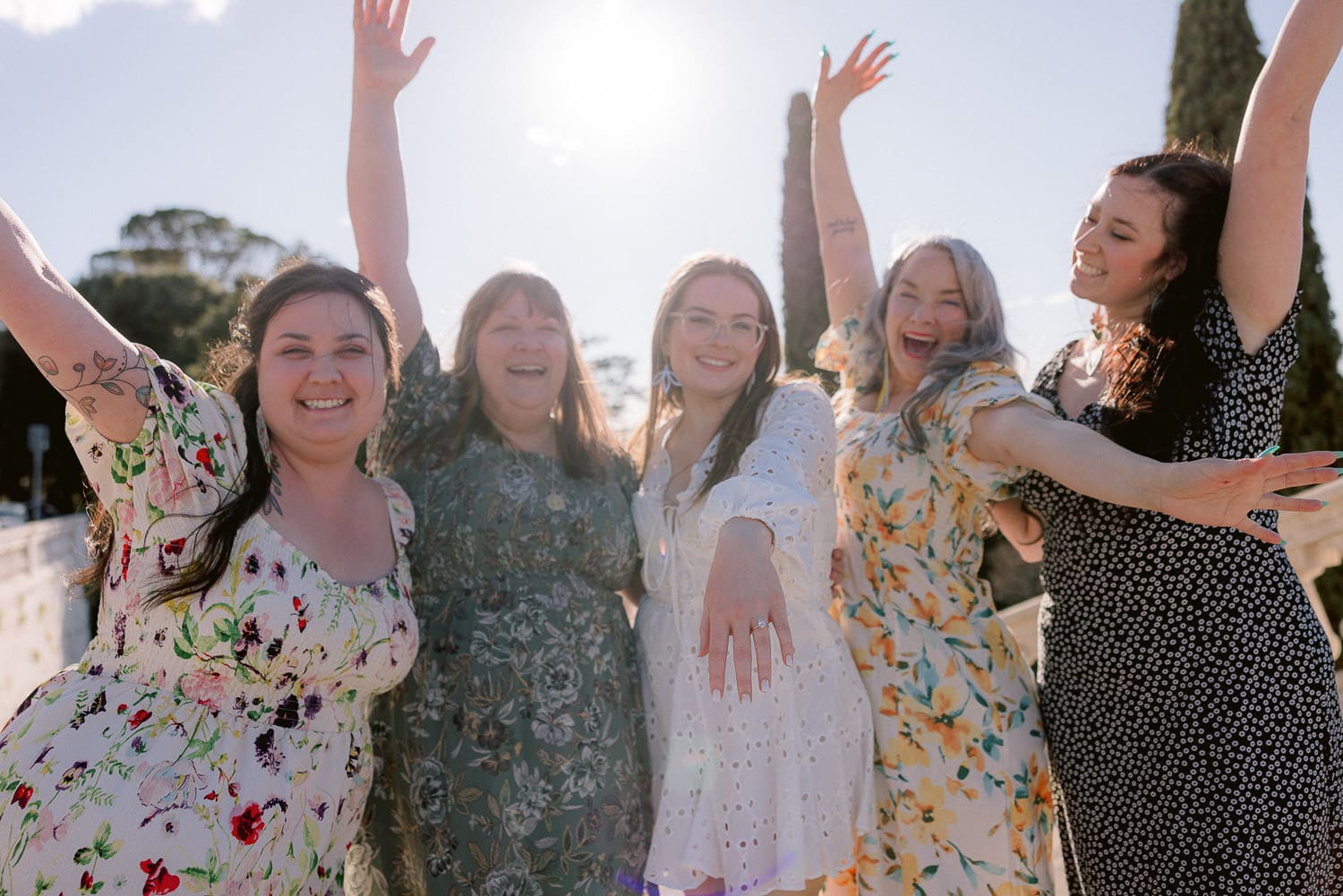 newly engaged girl showing her ring to the camera with her happy family all around her